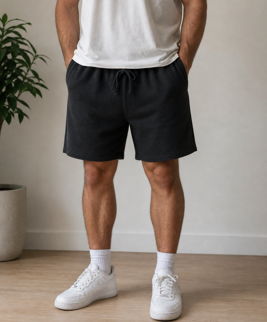 Person wearing black shorts and white sneakers in a minimal indoor setting. Hemp Horizon
