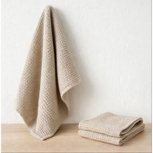 Beige textured towels on a wooden surface with a white background