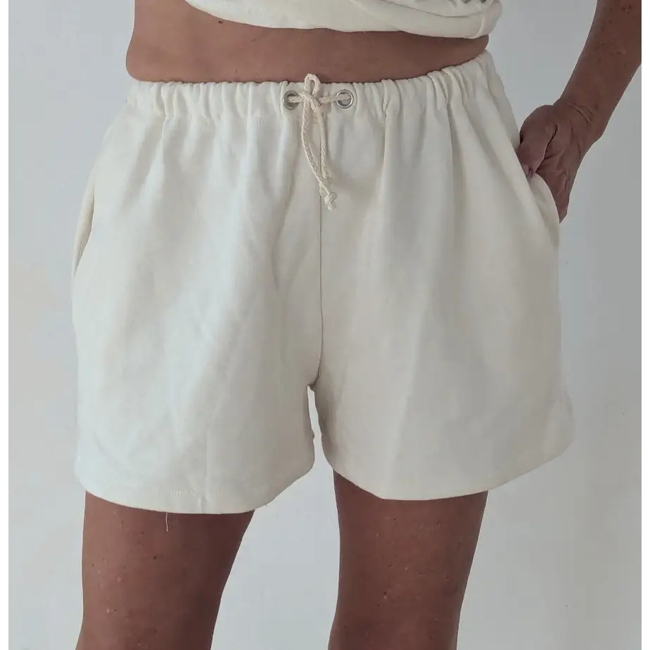 Person wearing beige shorts on a plain background